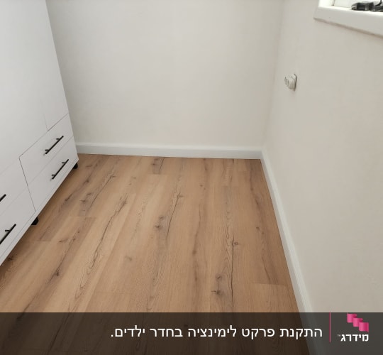 רצפת פרקט עץ בהירה ליד ארון לבן